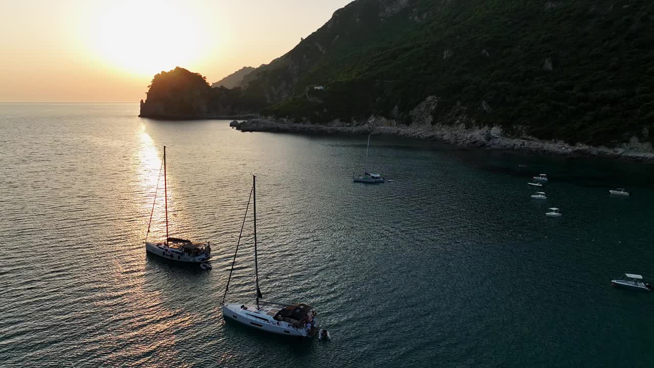 在宁静的日落中，帆船停泊在科孚岛平静的海湾里视频素材