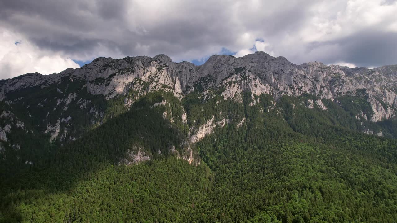 空中拍摄的多云天空下雄伟的皮亚特拉克雷乌鲁伊山脉，郁郁葱葱的森林视频素材