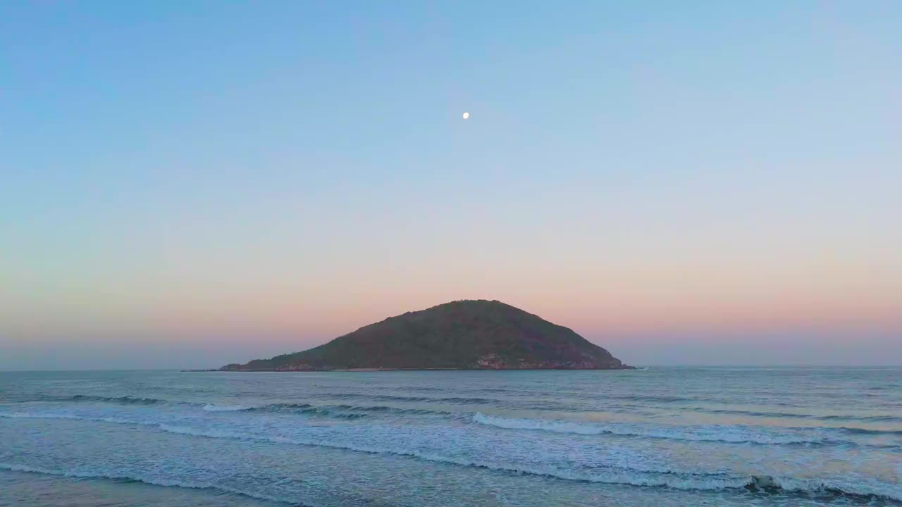 雄伟的黎明:鸟瞰岛屿与月亮，海鸥，和早晨的海浪视频素材