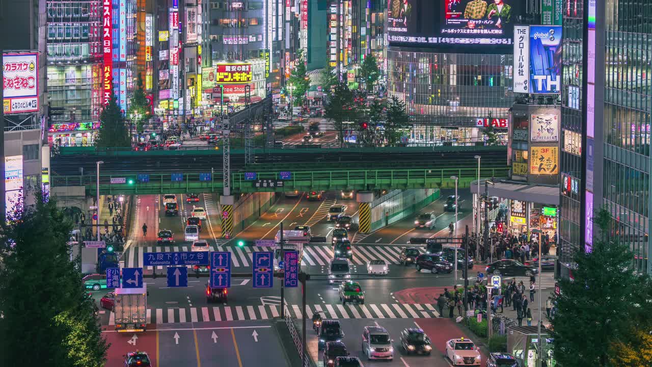 日本东京新宿地区繁忙的街道交汇处，许多行人步行和车辆通勤的延时拍摄。视频下载