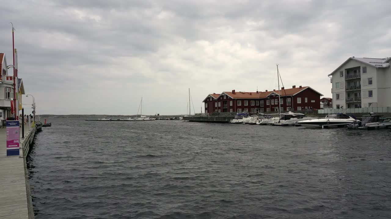 瑞典斯莫根多云的天空下，Munkkyrkan海滨别墅和停泊的船只的美景视频素材