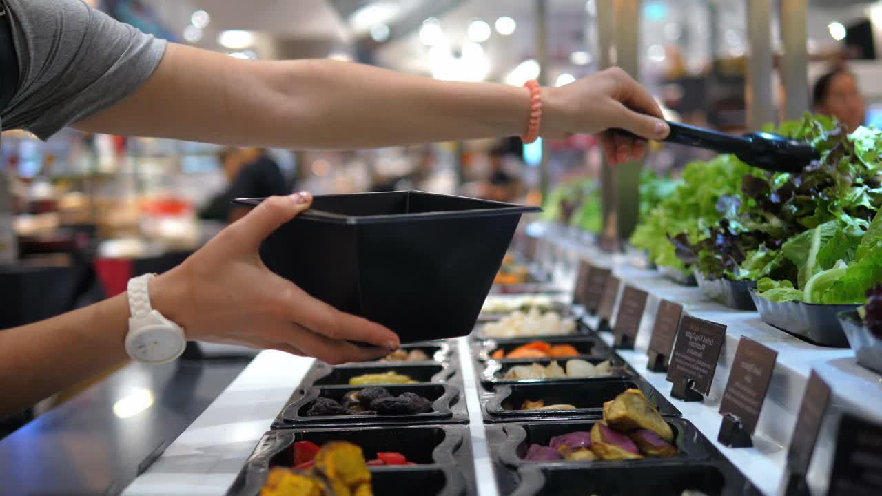 素食妇女在健康食物点准备晚餐，沙拉选择各种新鲜蔬菜作为素食的基础，素食者特别注意食物的选择，以达到均衡饮食视频下载