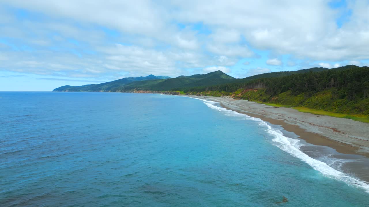 海岸线的俯视图与山脉在地平线上的海岸。夹。沿海有绿色森林和山脉的岛屿。天堂的地方，放松在野生的岛屿海岸与山视频素材