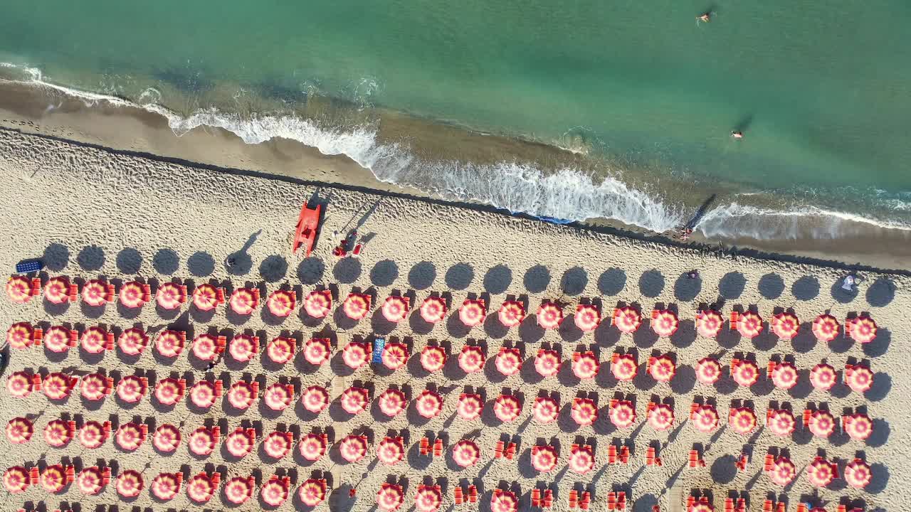 夏季来临的沙滩伞的鸟瞰图，大自然的无人机视频下载