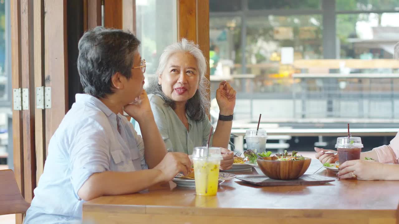 一群亚洲老年妇女在餐厅共进午餐。视频下载