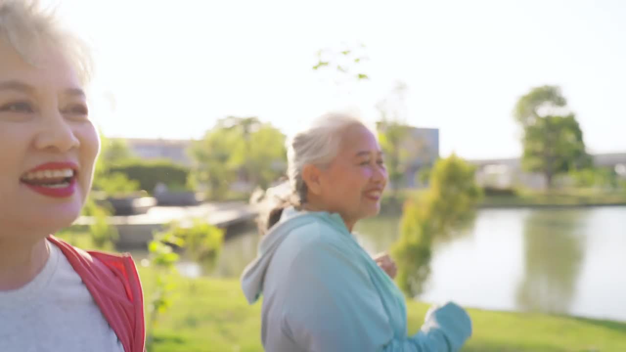 一群开朗活泼的老年妇女在公园一起慢跑视频下载