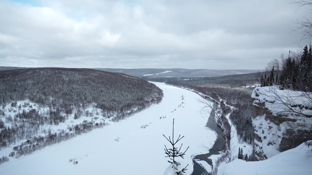 冬季景观寒冷宽阔的河流。夹。冰封的风景，有森林和弯曲的河流。视频素材