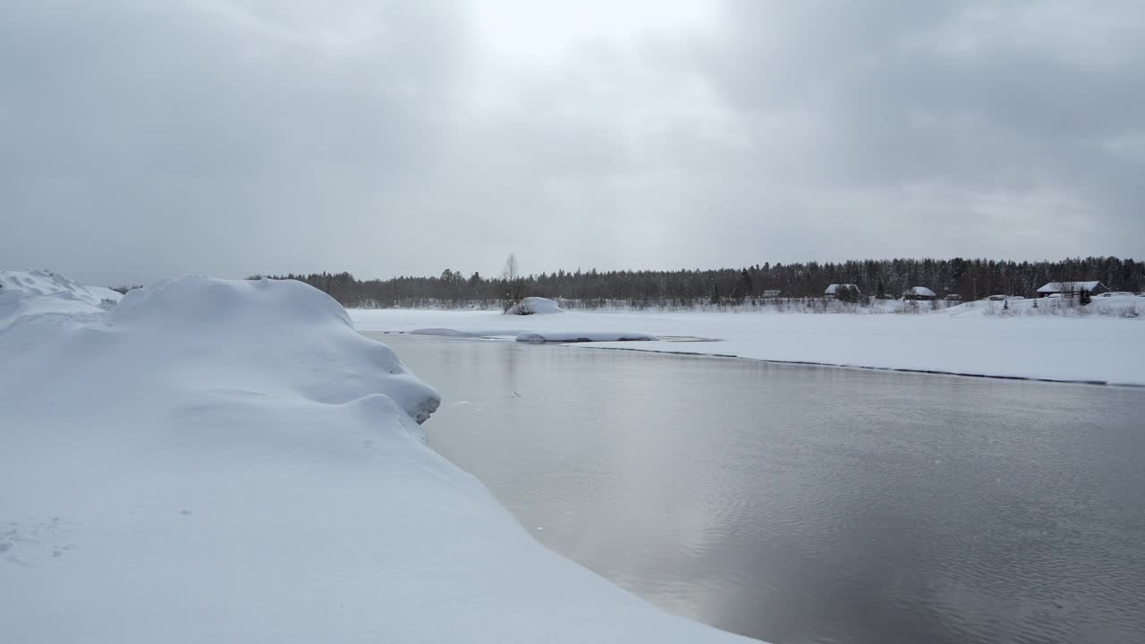 冬季景观寒冷宽阔的河流。夹。冰封的风景，有森林和弯曲的河流。视频素材