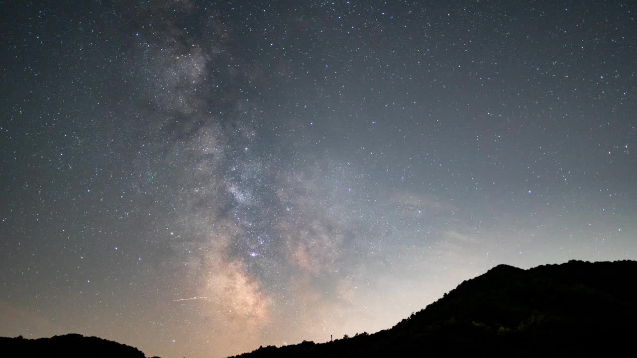 银河在夜晚的山峰上冉冉升起，星星闪烁，时间流逝视频素材