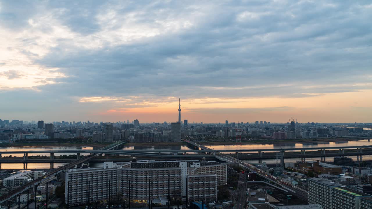 东京天空树从白天到夜晚，拍摄于船堀的一座高层建筑。建筑上的灯打开了，道路上交通的灯开始亮起来，4K视频下载