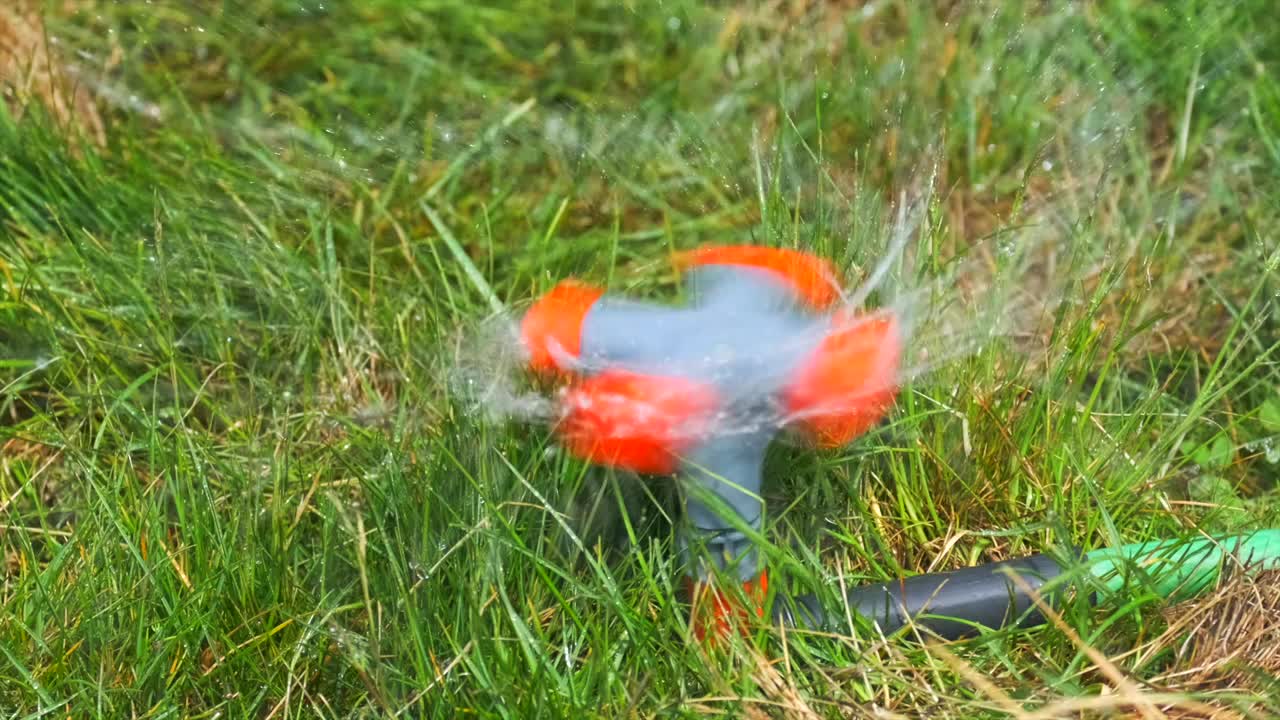 全自动花园草坪洒水器浇草，背景，特写。视频素材