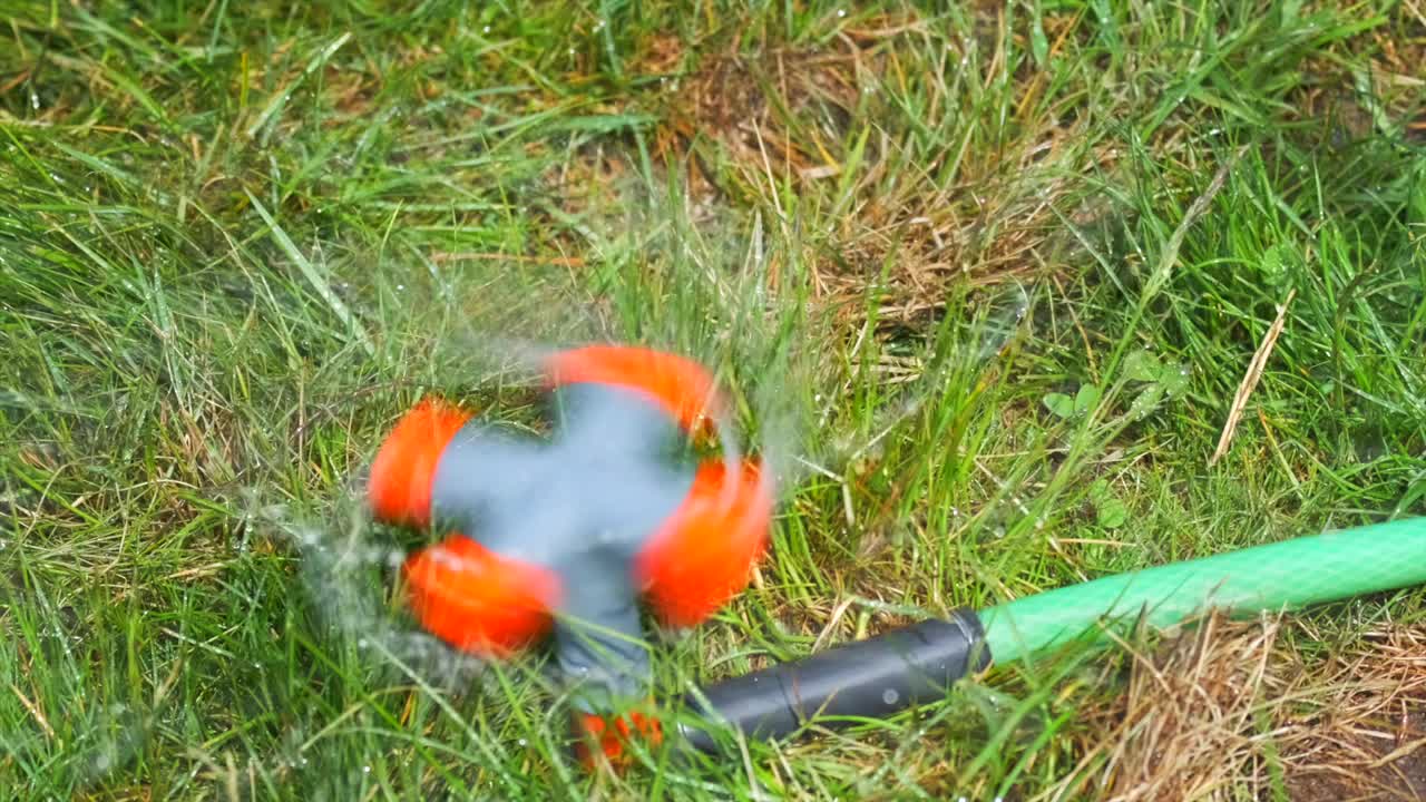 自动草坪洒水器，近距离浇灌绿草。视频素材