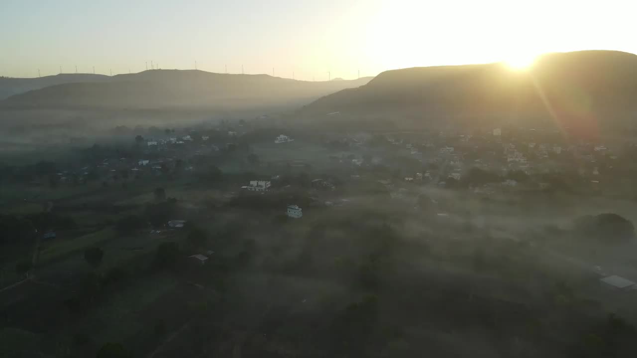 空中无人机拍摄的雾气笼罩的村庄里神秘的日出画面视频下载