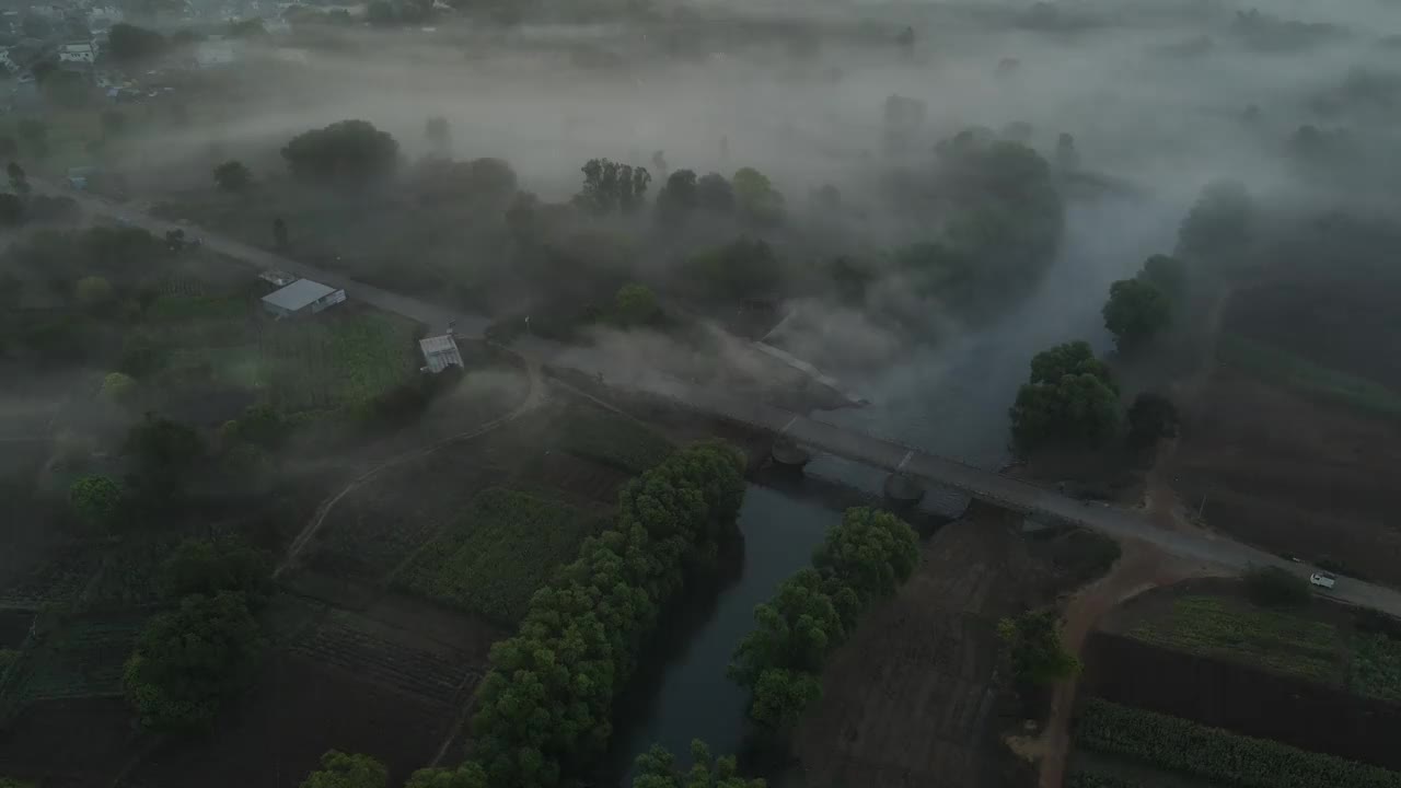 空中无人机拍摄的雾气笼罩的村庄里神秘的日出画面视频下载