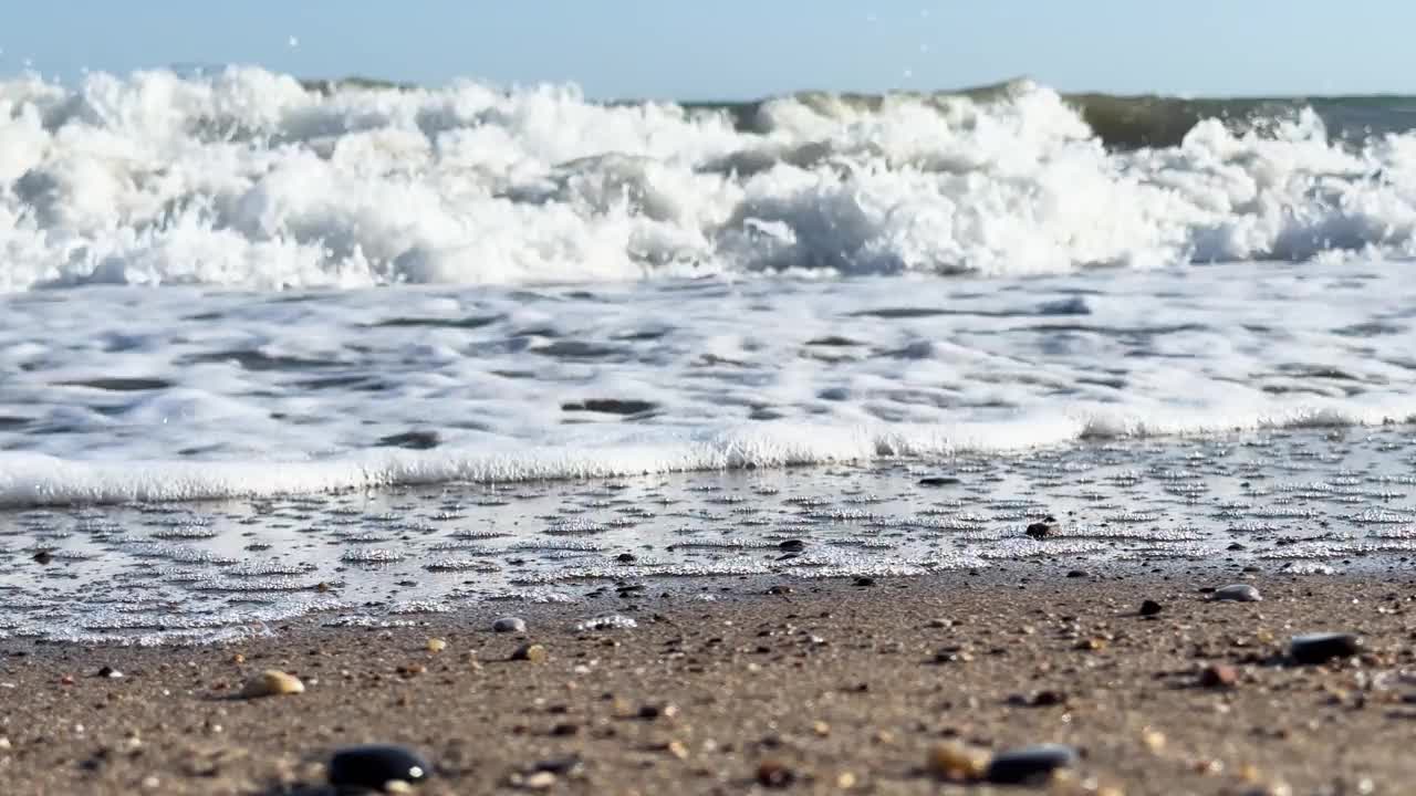 美丽的蓝色大海和平静的大浪。海浪拍打着海上的鹅卵石。翻滚的海浪。夏日天堂海滩背景。强大的海浪视频素材