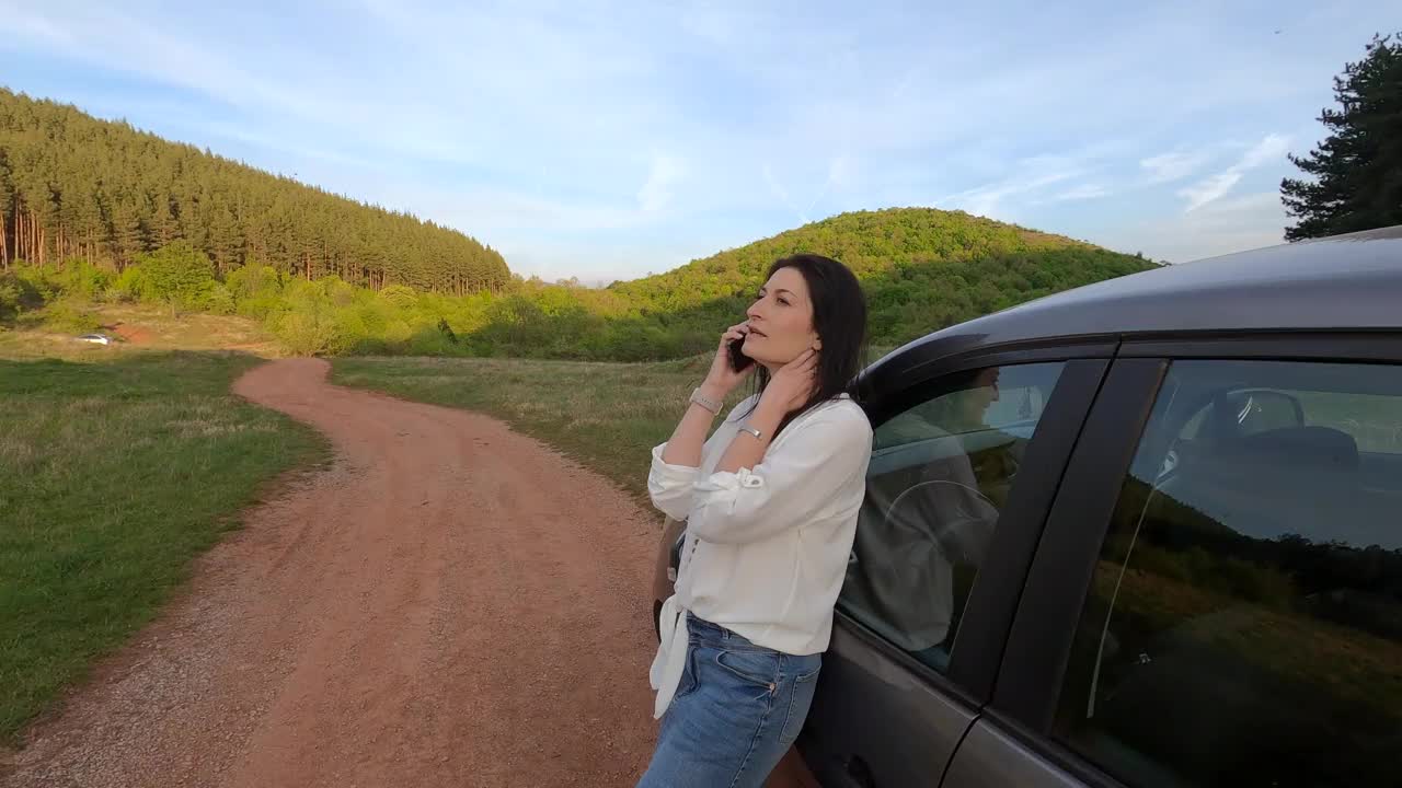 一个女人正在享受她的森林之旅。日落时美丽的景色和大自然的声音。她正在使用手机。视频素材