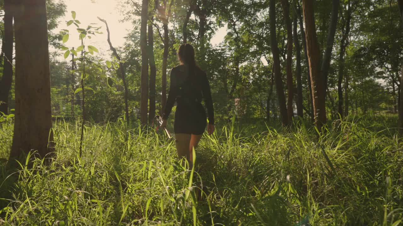 一个女人正穿过一片长着高高的草的森林视频下载