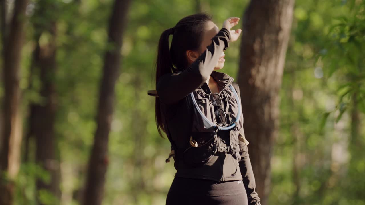 一个女人站在森林里，穿着黑色夹克，戴着太阳镜视频下载
