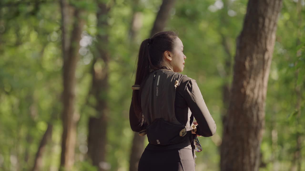 一个女人背着背包走在森林里视频下载