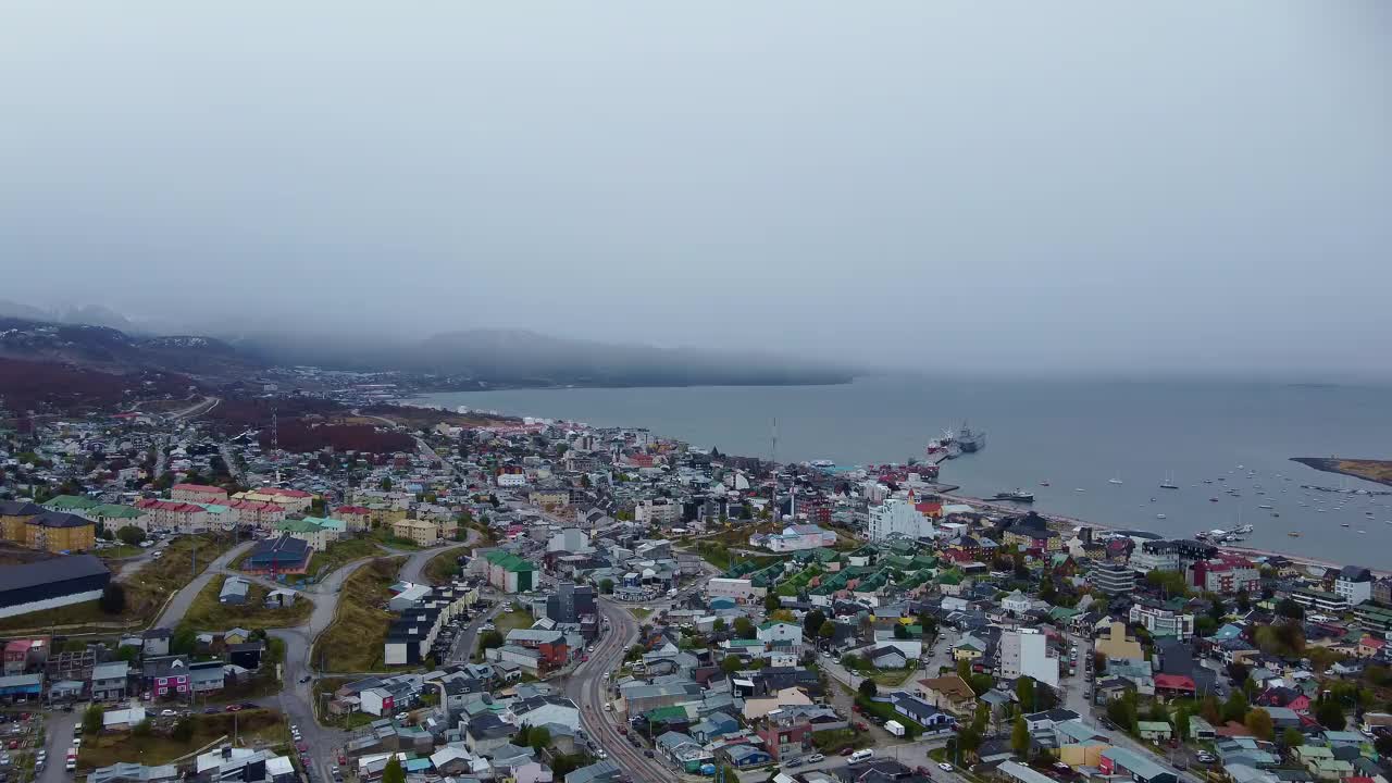 傍晚时分的乌斯怀亚市，灯火通明，前景是湖泊，背景是雪山。阿根廷巴塔哥尼亚,视频下载