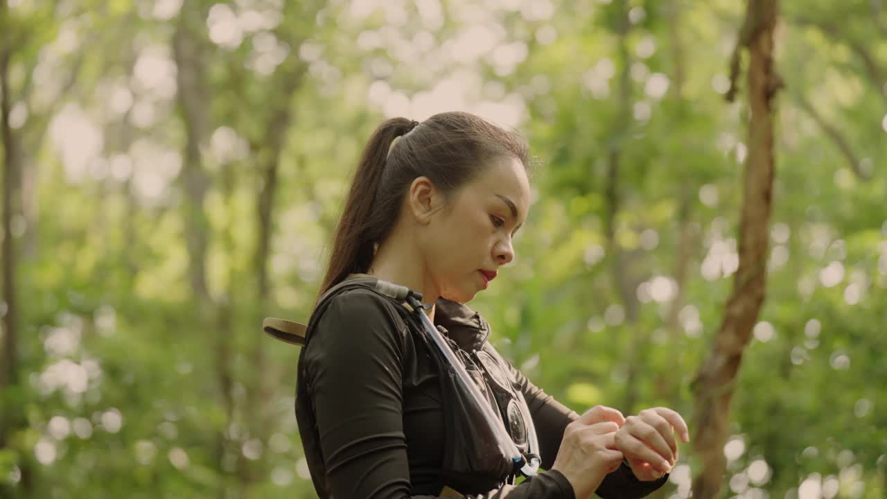 一个女人坐在森林里，穿着一件黑衬衫和一件黑背心视频下载