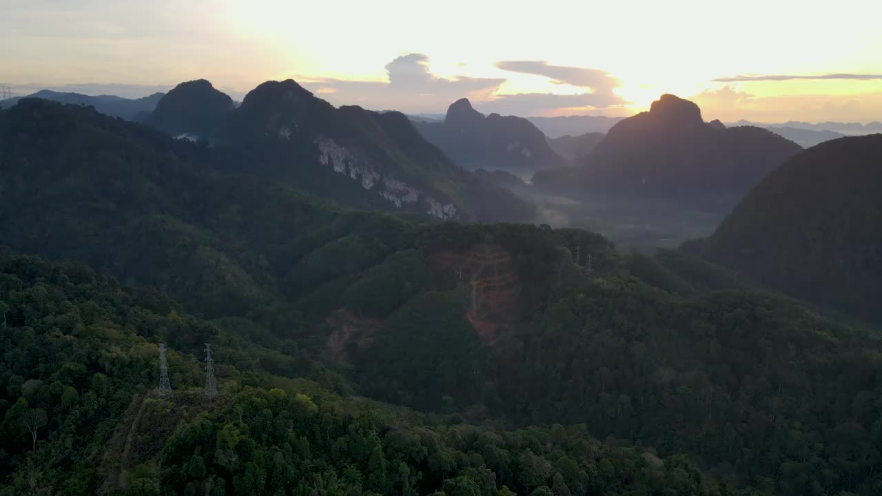 第一缕阳光从山顶后面照过来，鸟瞰图上是一片美丽的热带森林视频素材