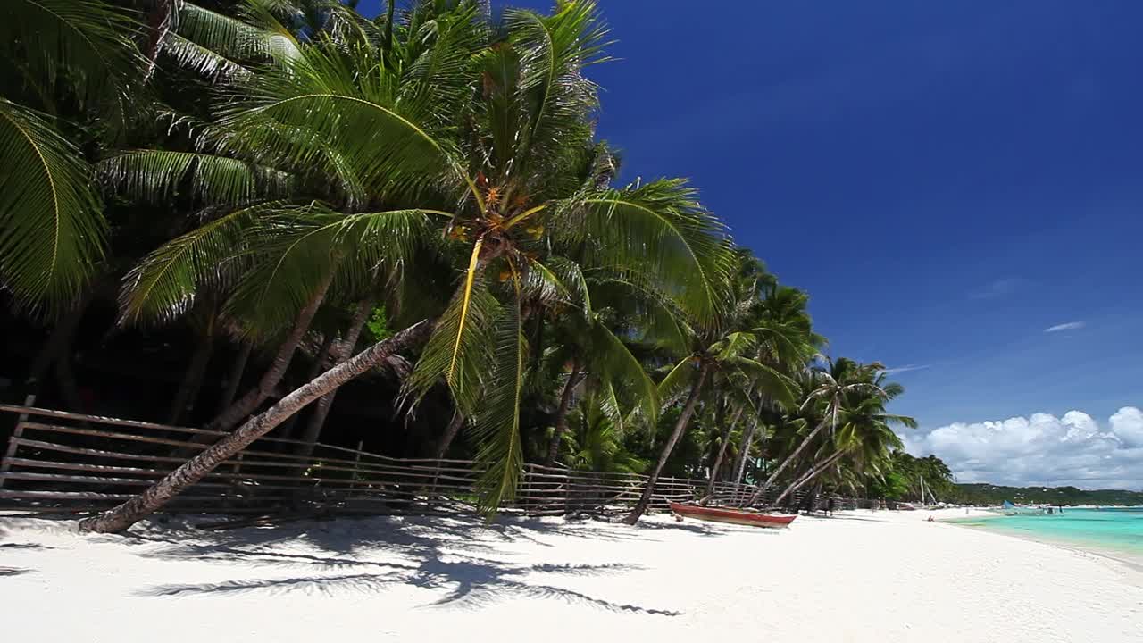 原始的海滩上有棕榈树，白色的沙滩和绿松石般的热带海洋。旅游目的地视频素材