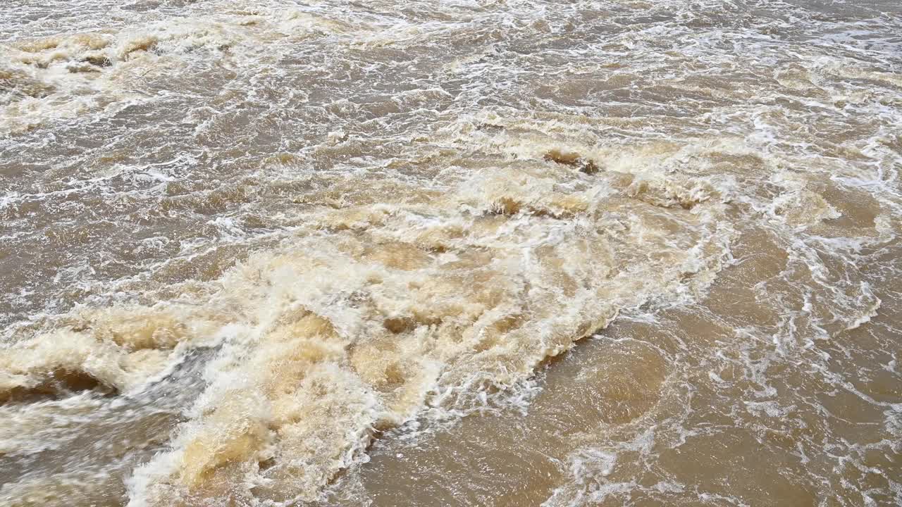 大雨过后，泥泞湍急的河水泛滥。视频素材