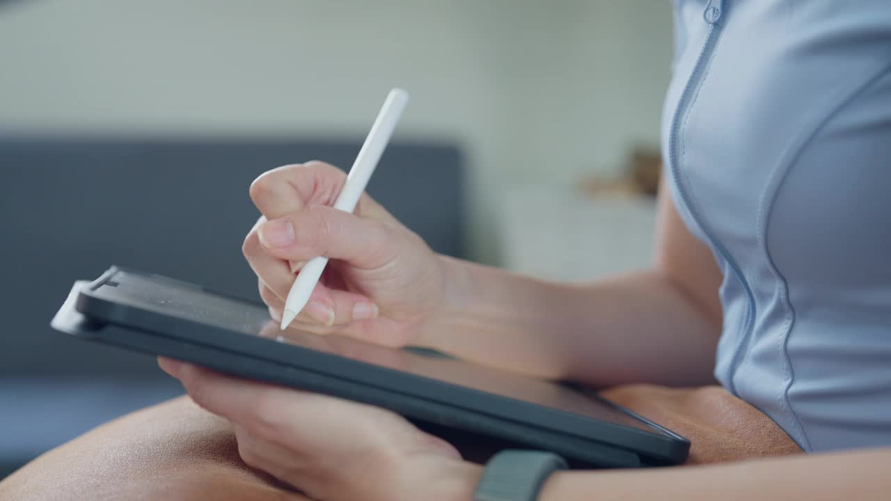 一个女人正在用一支白色的笔在写字板上写字视频下载