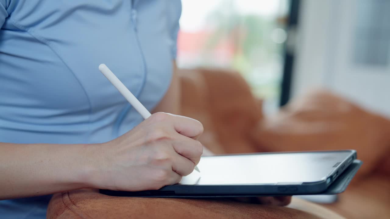 一位女士正在用触控笔在平板电脑上写字视频下载
