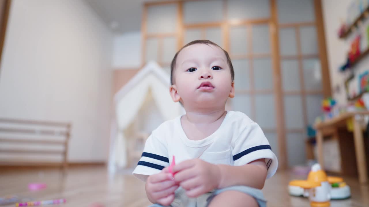 两岁的孩子独自坐在客厅地板上玩耍，想象中的朋友。视频素材