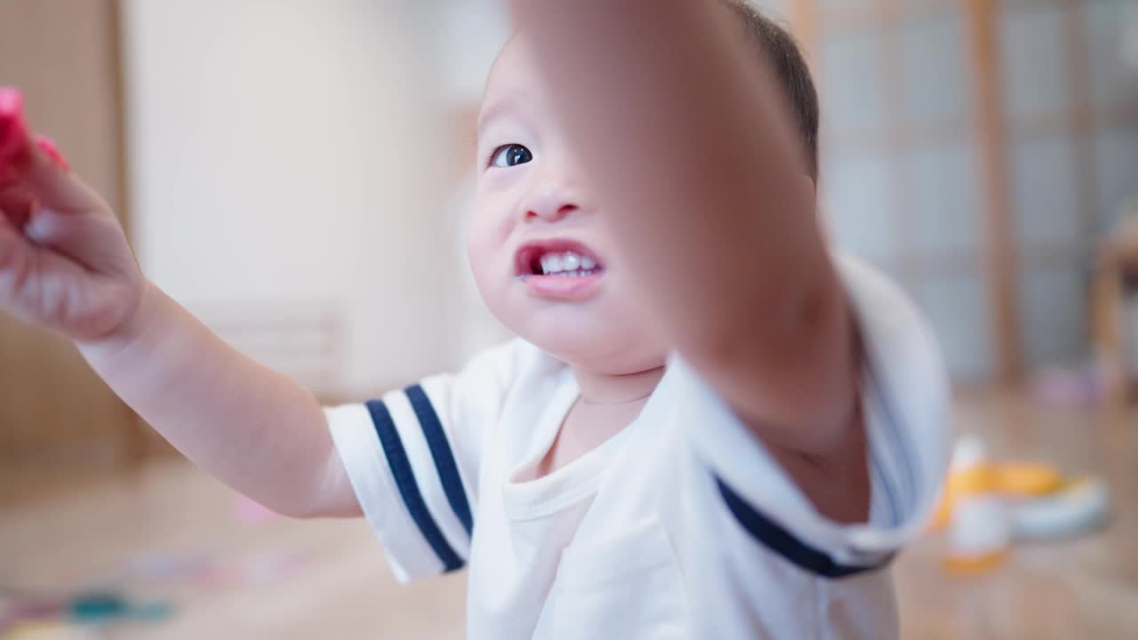 近距离拍摄了一个亚洲可爱的困惑婴儿，一天在家里的客厅里玩耍时露出好奇的表情。视频素材