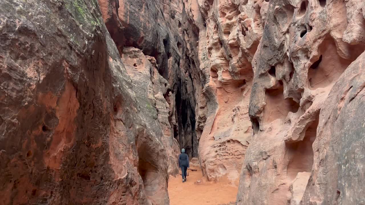 一位女士走过雪峡谷州立公园里美丽的红砂岩狭缝峡谷视频素材