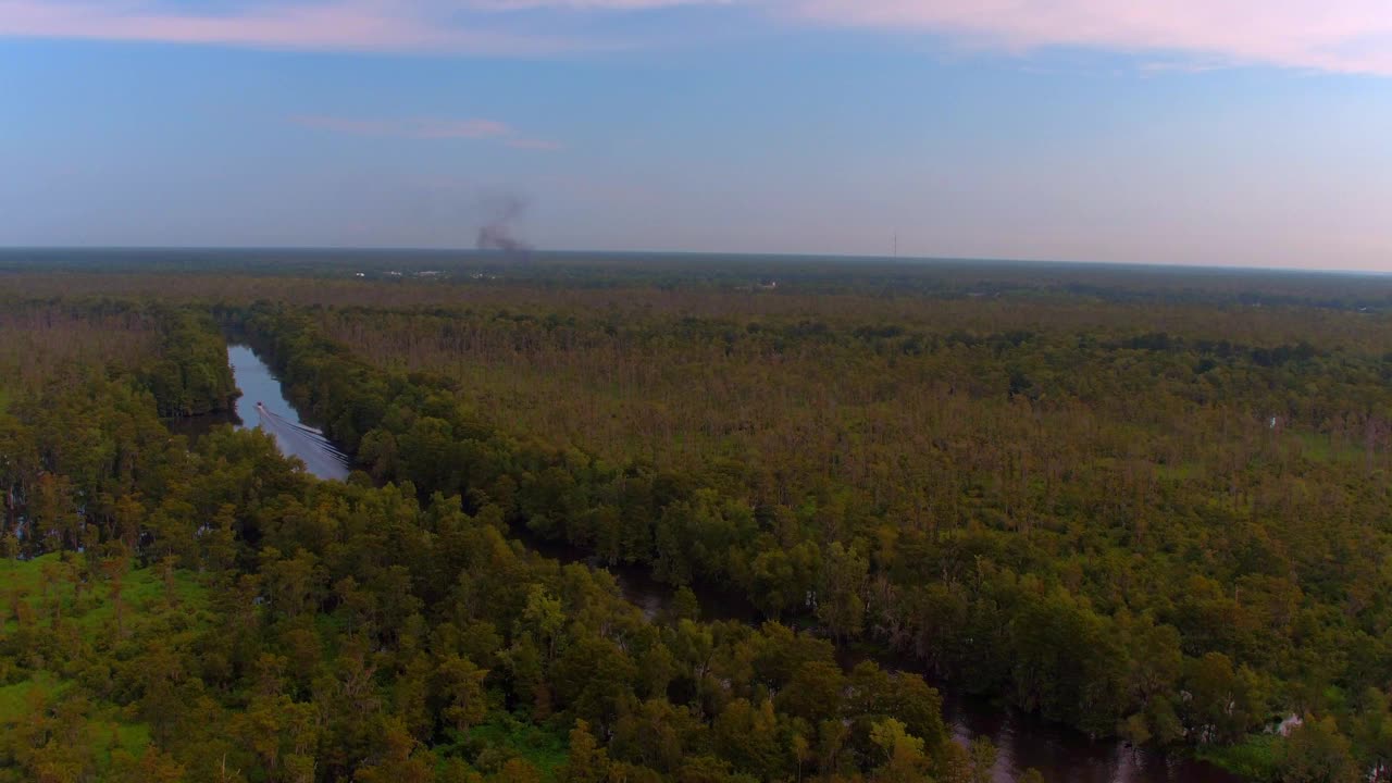 航拍的风景拍摄摩托艇在宁静的绿色丛林河上移动- Bayou Vista，德克萨斯州视频素材