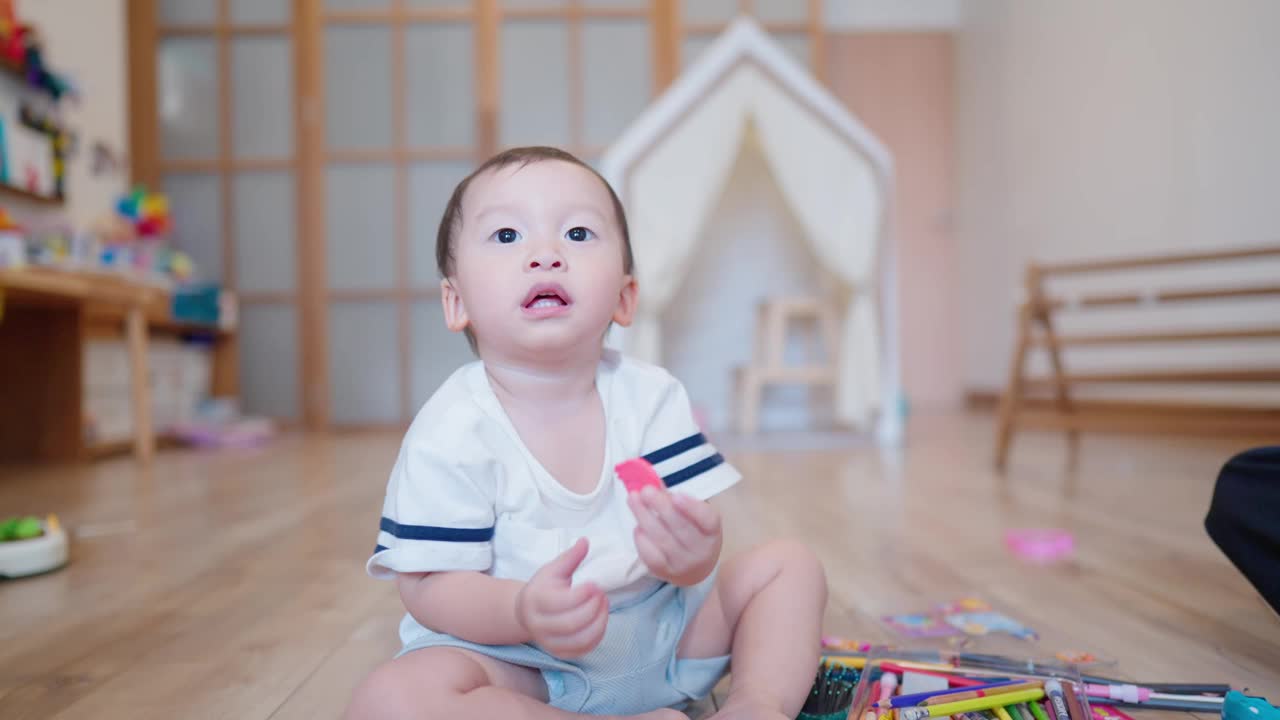 亚洲男孩在家里的客厅里独自坐下来玩耍。视频素材