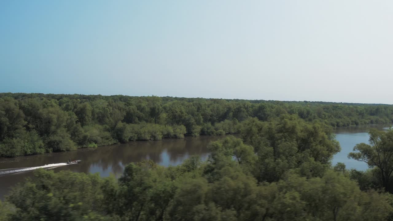 航拍风景摩托艇在河上移动，无人机飞越绿色的树木在森林里在阳光明媚的日子- Bayou Vista，德克萨斯州视频素材