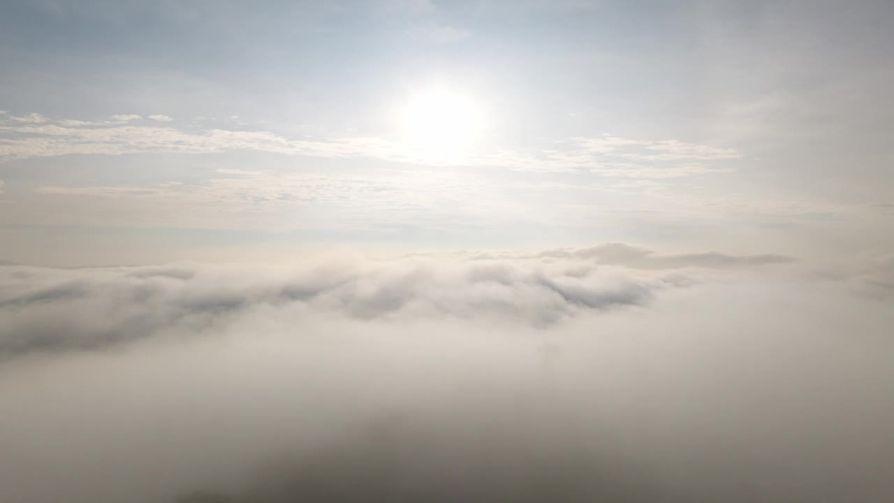 一架无人机在山顶电信站上空的薄雾或白云上拍摄超延时视频。视频素材