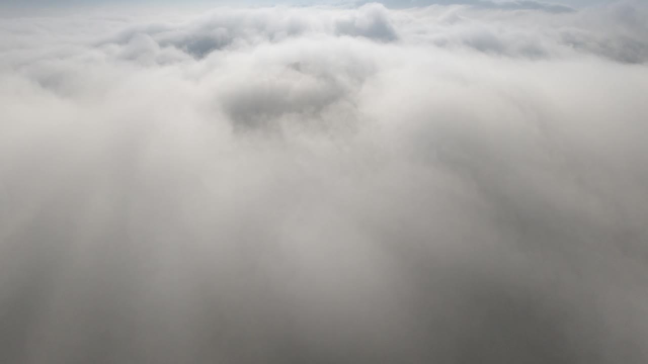 一架无人机在山顶电信站上空的薄雾或白云上拍摄超延时视频。视频素材