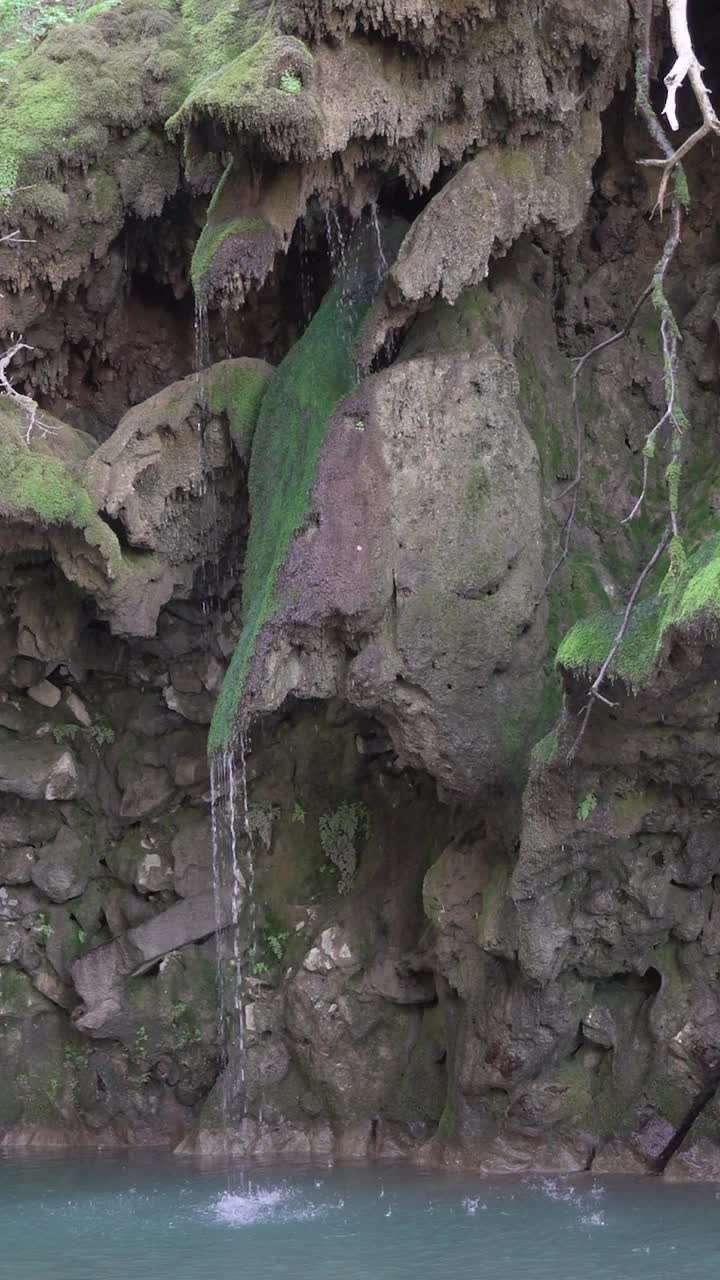 小溪顺着长满青苔的山坡流进绿松石般的山湖，垂直感十足视频素材