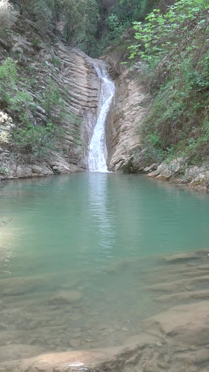 山河瀑布的溪水落入山湖垂直景观视频素材