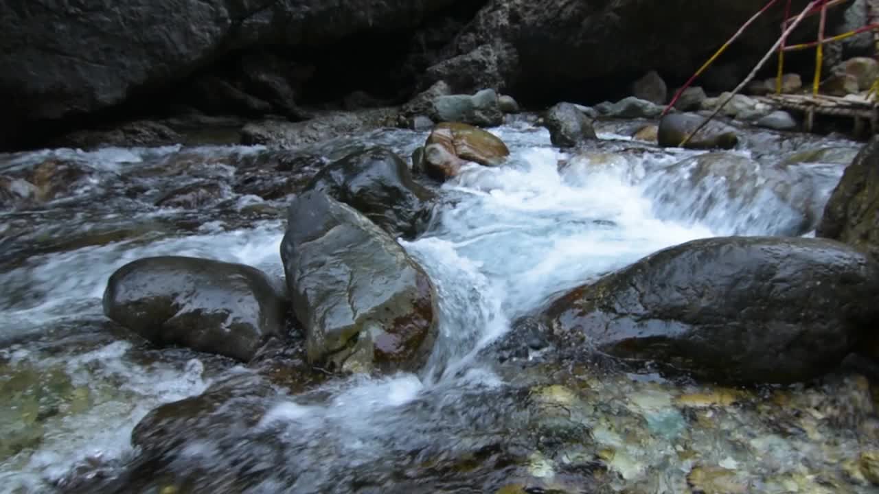 美丽的山景，贾安提河穿过岩石和河上的木桥。视频下载