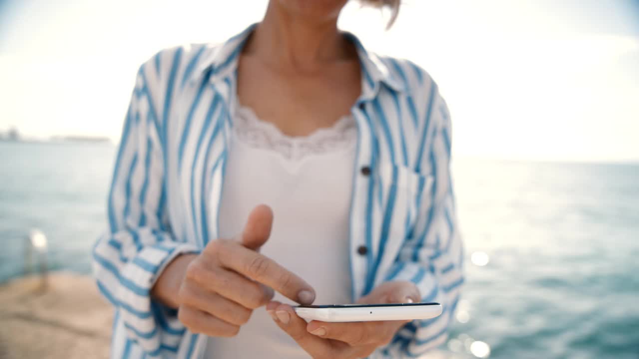 在海边发短信的白人女人视频素材