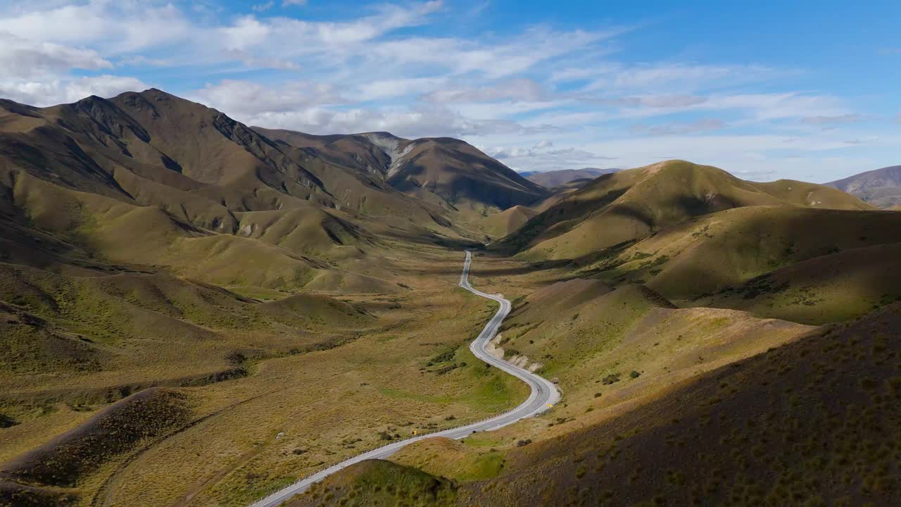 蜿蜒的道路在谷底和山脉穿过林迪斯山口，空中视频素材