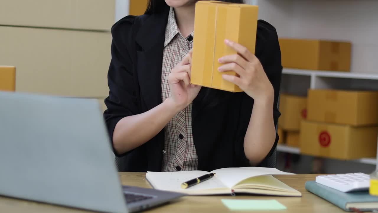 年轻的亚洲女性在家里做小生意的直播，用笔记本电脑在网上和客户谈销售。视频素材