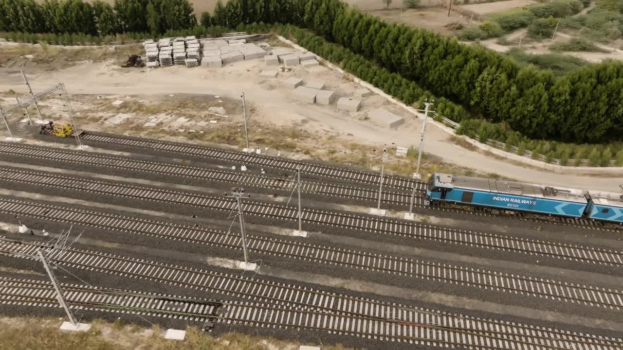 在印度西部古吉拉特邦，印度铁路货运机车缓慢走向一个工业工厂进行货物装卸的4K航空无人机视频视频下载