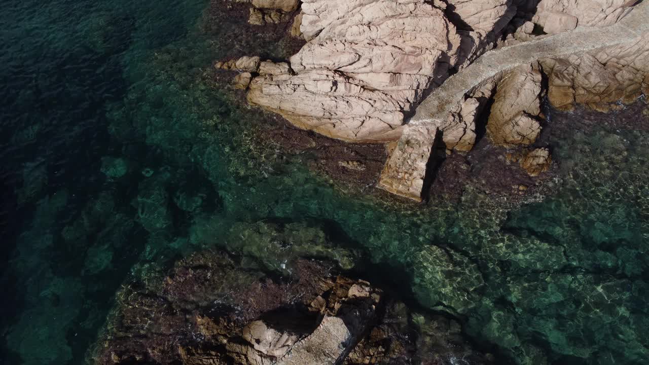 罗萨马岛礁石上破碎的走道鸟瞰图。清澈的水在Camí de Ronda，圣克里斯蒂娜德阿罗，布拉瓦海岸，加泰罗尼亚视频下载