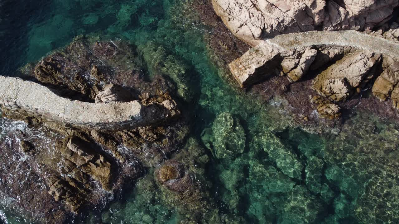 地中海一条破损人行道的无人机视图。清澈的水在Camí de Ronda，圣克里斯蒂娜德阿罗，布拉瓦海岸，加泰罗尼亚视频下载