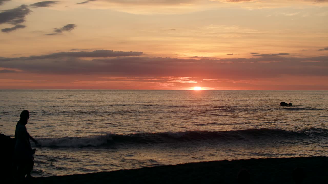 一对夫妇的剪影走在海上夕阳，夕阳地平线线视频素材