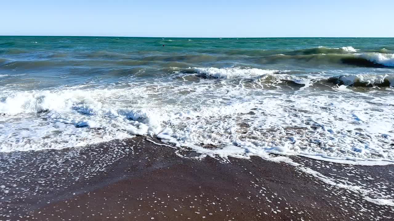 美丽的蓝色大海和巨大的平静的波浪和泡沫。海浪拍打着海上的鹅卵石。翻滚的海浪。夏日天堂海滩背景。强大的海浪视频下载