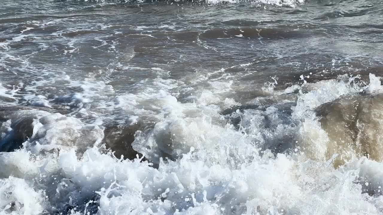 有泡沫的平静巨浪。海浪拍打着海上的鹅卵石。翻滚的海浪。夏日天堂海滩背景。强大的海浪视频素材